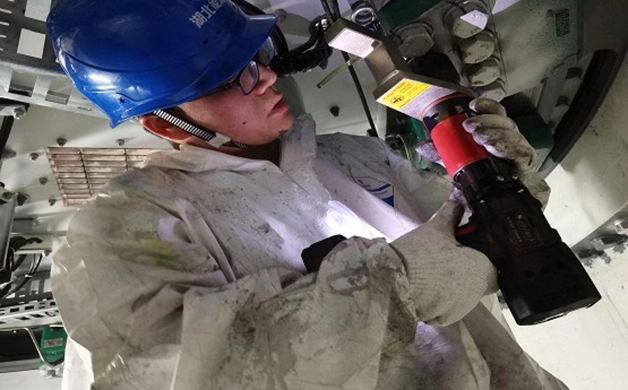 運維人員袁才波正在狹小的空間內打力矩(攝影:張鍵鍵) 運維人員袁才波正在狹小的空間內打力矩(攝影:張鍵鍵)